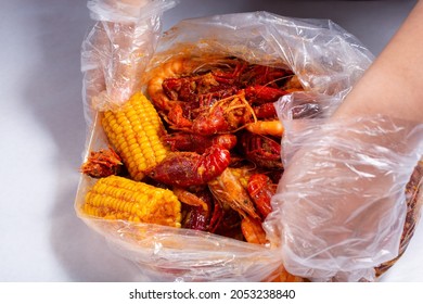 A View Of Hands Opening A Plastic Bag Full Of Seafood Boil, At A Local Restaurant.