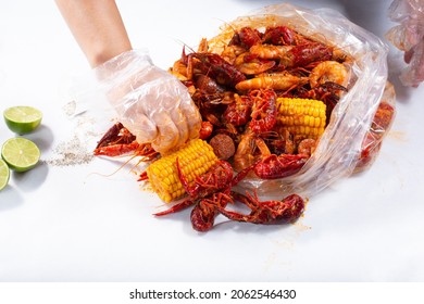 A View Of Hands Opening A Plastic Bag Full Of Seafood Boil, At A Local Restaurant.