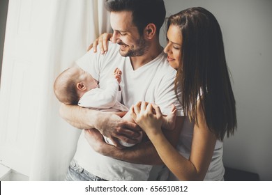 View At Happy Family With Newborn Baby By The Window