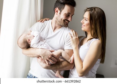 View At Happy Family With Newborn Baby By The Window