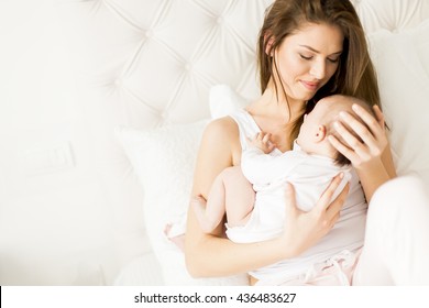 View At Happy Mother With Baby On Bed