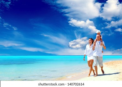 View Of Happy Young Family Having Fun On The Beach