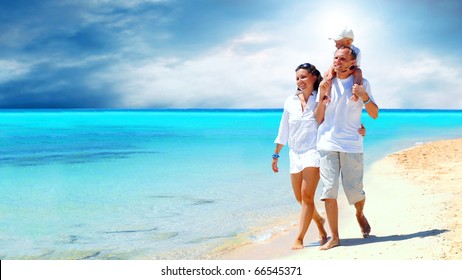 View of happy young family having fun on the beach - Powered by Shutterstock