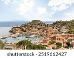 View to harbour and old town of Giglio Porto at Isola del Giglio, island of the tuscan archipelago, beautiful ancient rustico buildings and ferry terminal to Porto San Stefano, Grosseto Tuscany Italy