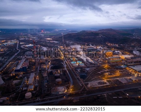 View of a heavily smoking factory at night, industrial area aerial view
