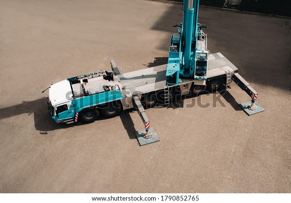 view\
from the height of the Car heavy crane that stands open in the\
Parking lot and ready to work. the highest truck crane is deployed\
on the site. the height of the boom is 80\
meters