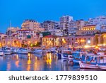 View of Heraklion city with harbour with yachts and fishing boats at dusk, Crete island, Greece. Greek scenery