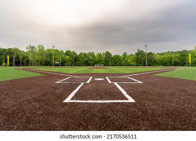 View of  high school synthetic turf baseball field looking from batters box toward the outfield.