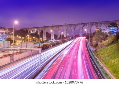 View Of Highway With Car Traffic And Light Trails. The Aguas Livres Aqueduct (Aqueduto Das Águas Livres) In Lisbon, Portugal