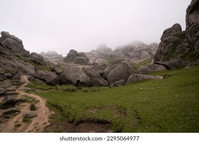 View of the hiking path across the rocky hill in a foggy early morning.