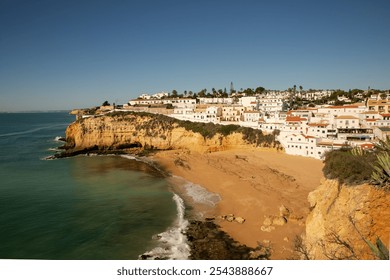 View from the hiking trail toward Benagil Cave in Algarve, showcasing white cliffside houses above turquoise ocean waves on a sunny day. - Powered by Shutterstock