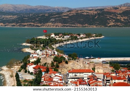 View of the historic part of Eğirdir with its castle in the middle of the lake of the same name and the mountains in the background in the Isparta region of southern Turkey