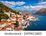 View of the historic town of Perast at famous Bay of Kotor on a beautiful sunny day with blue sky and clouds in summer, Montenegro. Historic city of Perast at Bay of Kotor in summer, Montenegro.