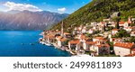 View of the historic town of Perast at famous Bay of Kotor on a beautiful sunny day with blue sky and clouds in summer, Montenegro. Historic city of Perast at Bay of Kotor in summer, Montenegro.