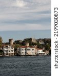 View of historical, traditional mansions and old Anatolian fortress by Bosphorus in Anadolu Hisari area of Asian side of Istanbul. It is a sunny summer day. Beautiful travel scene.