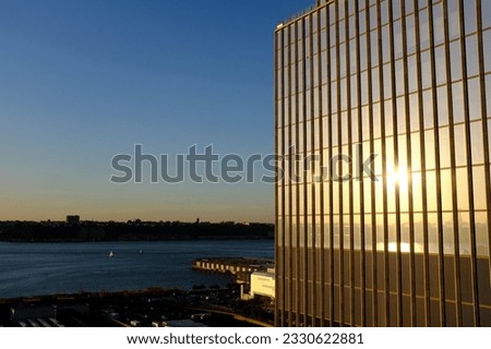 View of the Hudson River as seen from the Vessel, a structure and visitor attraction at the Hudson Yards. Near by is a large glass building reflection the evening light.