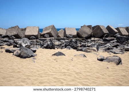 View of the huge concrete cubes which act as a breakwater at Playa las Vistas in the tourist resort town of Los Cristianos on the Spanish island of Tenerife.