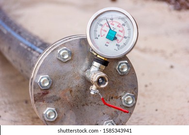 View of the hydrostatic testing of polyethylene pipeline and manometer (pressure gauge). EN 837-1 is a standard to produce for manometer. Cl 1,0 is a class of gauge. Bar (psi) is pressure unit.