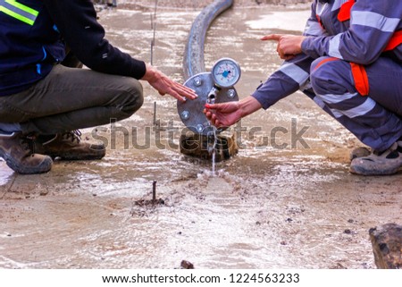 View of the hydrostatic testing of the polyethylene pipeline and a manometer gauge.