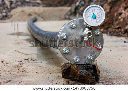 View of the hydrostatic testing of the polythene pipeline and manometer (pressure gauge). Hydrostatic test is a way in which pressure vessels such as pipelines can be tested for strength and leaks.