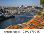 View of the iconic Dom Luis I - double-deck metal arch bridge (172 meters, 1886) crossing the Douro River and the historical Ribeira and Se District in the city of Porto, Portugal. 