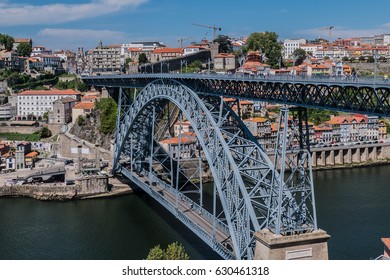View of the iconic Dom Luis I - double-deck metal arch bridge (172 metres, 1886) crossing the Douro River and the historical Ribeira and Se District in the city of Porto, Portugal.