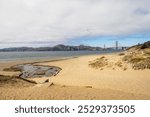 View of the iconic Golden Gate Bridge from Baker Beach, showcasing the stunning coastal landscape of San Francisco.