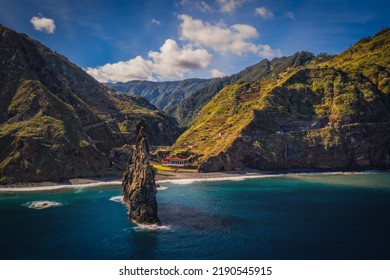 View of the Ilheus da Ribeira da Janela rock islets under a clear blue sky. The rocks form a famous landmark on the northern shore of the island of Madeira, Portugal. Aerial drone shot, october 2021 - Powered by Shutterstock