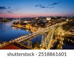 View of illuminated Porto city and Douro river and Dom Luis bridge I from famous tourist viewpoint Miradouro da Serra do Pilar in evening twilight. Porto, Vila Nova de Gaia, Portugal