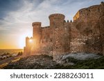 View of the impressive medieval fortress and castle of Belmonte in Cuenca, Spain at sunset and backlit