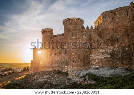 View of the impressive medieval fortress and castle of Belmonte in Cuenca, Spain at sunset and backlit