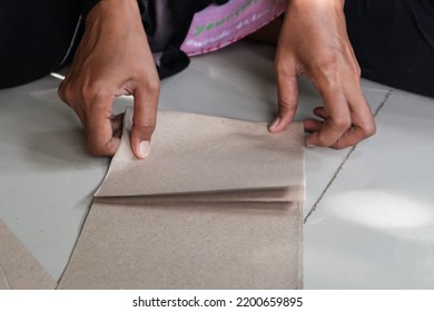 View Of Indonesian Women Is Folding The Paper Into A Smaller Size 