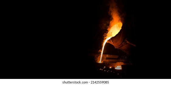 View of industrial metal casting. The process of for filling out mold with molten metal. Industrial panoramic view with black writing area. - Powered by Shutterstock