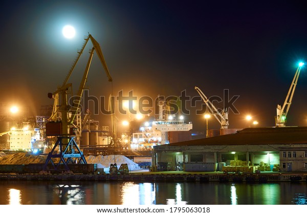 view of the\
industrial port at night - ships waiting for loading and unloading,\
cargo transportation by\
sea