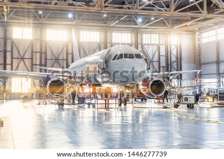 View inside the aviation hangar, the airplane mechanic working around the service