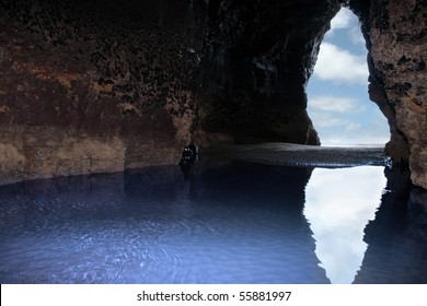 a view from the inside of a beach cave looking out at the sea