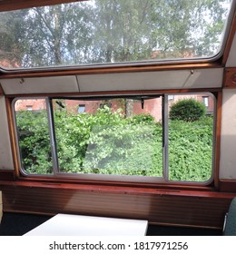 A view from inside of a boat canal showing its window frames the beautiful vegetation of the outside( Birmingham canal) 