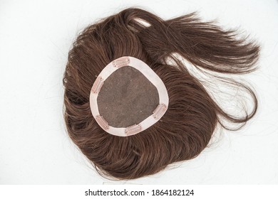 View Of The Inside Of A Brunette Toupee Or Hair Topper Showing The Clips Against A Plain White Backdrop.