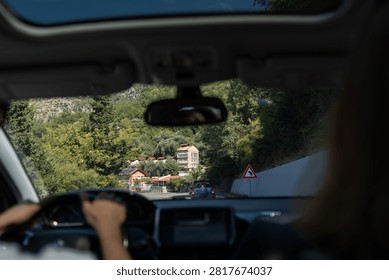 View from inside a car driving through a mountain road in Montenegro, capturing road trip atmosphere and scenic countryside landscape