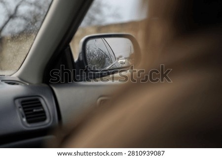 View from inside a car with a reflection of traffic in the wing mirror.