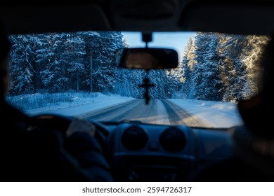 A view from inside a car through the windshield of a snowy Russian highway.