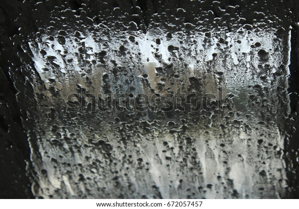 View from inside a car\
wash. Soap and water splashing on car window creating tiny water\
droplets. 