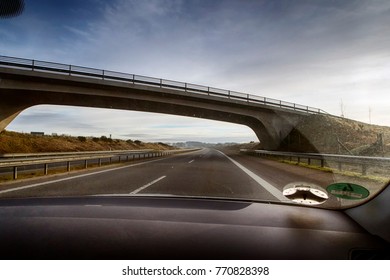 View from inside a car while driving on an highway close to a bridge in Denmark.