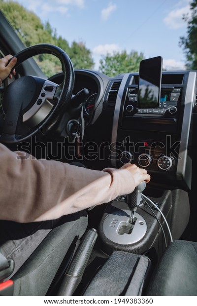 view from inside of the car woman hands on\
steering wheel and gearbox. copy\
space