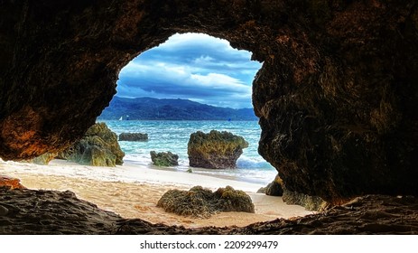 View from inside of cave to the beach and blue sea. Island of Boracay Philippines