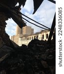 View from inside of the destroyed building. A large ruined building with a pile of construction debris and concrete debris. The cut object. Consequences of the war.