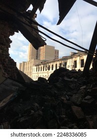 View from inside of the destroyed building. A large ruined building with a pile of construction debris and concrete debris. The cut object. Consequences of the war.