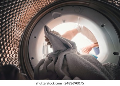 View from inside the drum of a washing machine: a man loads or unloads laundry. Laundry.
Interior view of the washing machine. - Powered by Shutterstock