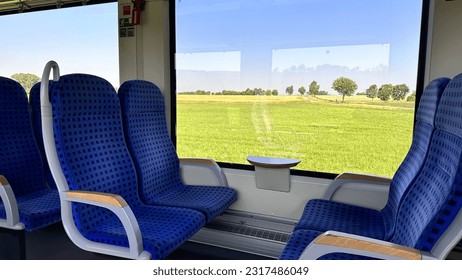 View inside a German regional train. Beautiful view from the comfortable car of the German regional train. Comfortable wagon. Empty seats in a railroad car. Horizontal photo