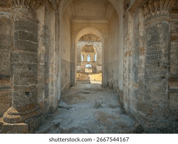 view inside interior of abandoned cathedral through main entrance with columns